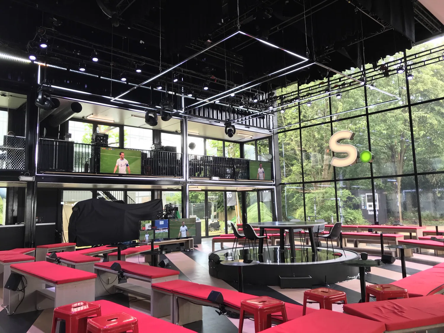Glass-walled Villa Sporza 2018 studio with red benches and digital LED strips