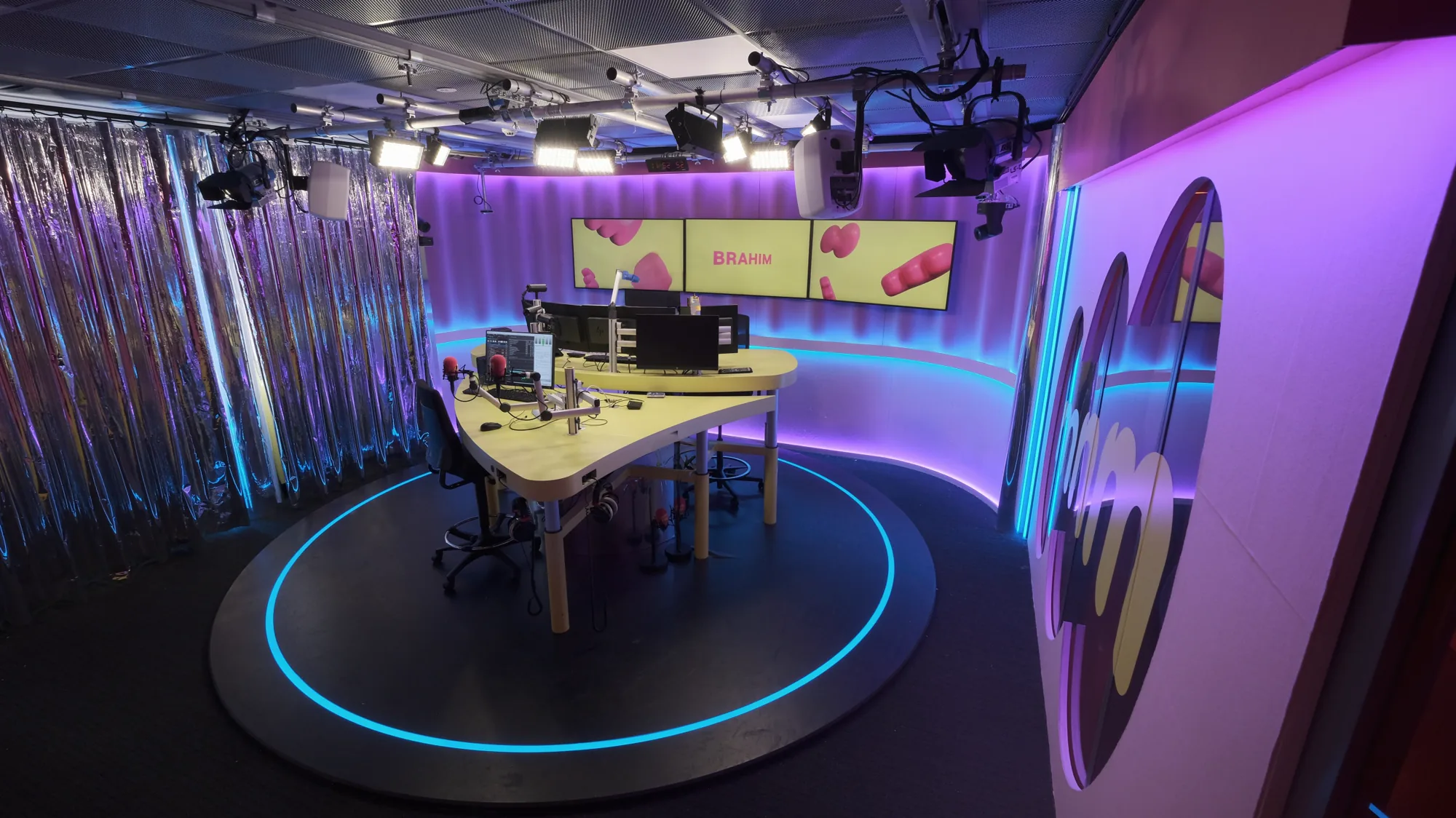 Renewed MNM studio with a blue LED circle in the floor and logo wall