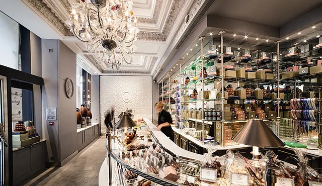 Illuminated shop interior with a chandelier and lit wall shelving