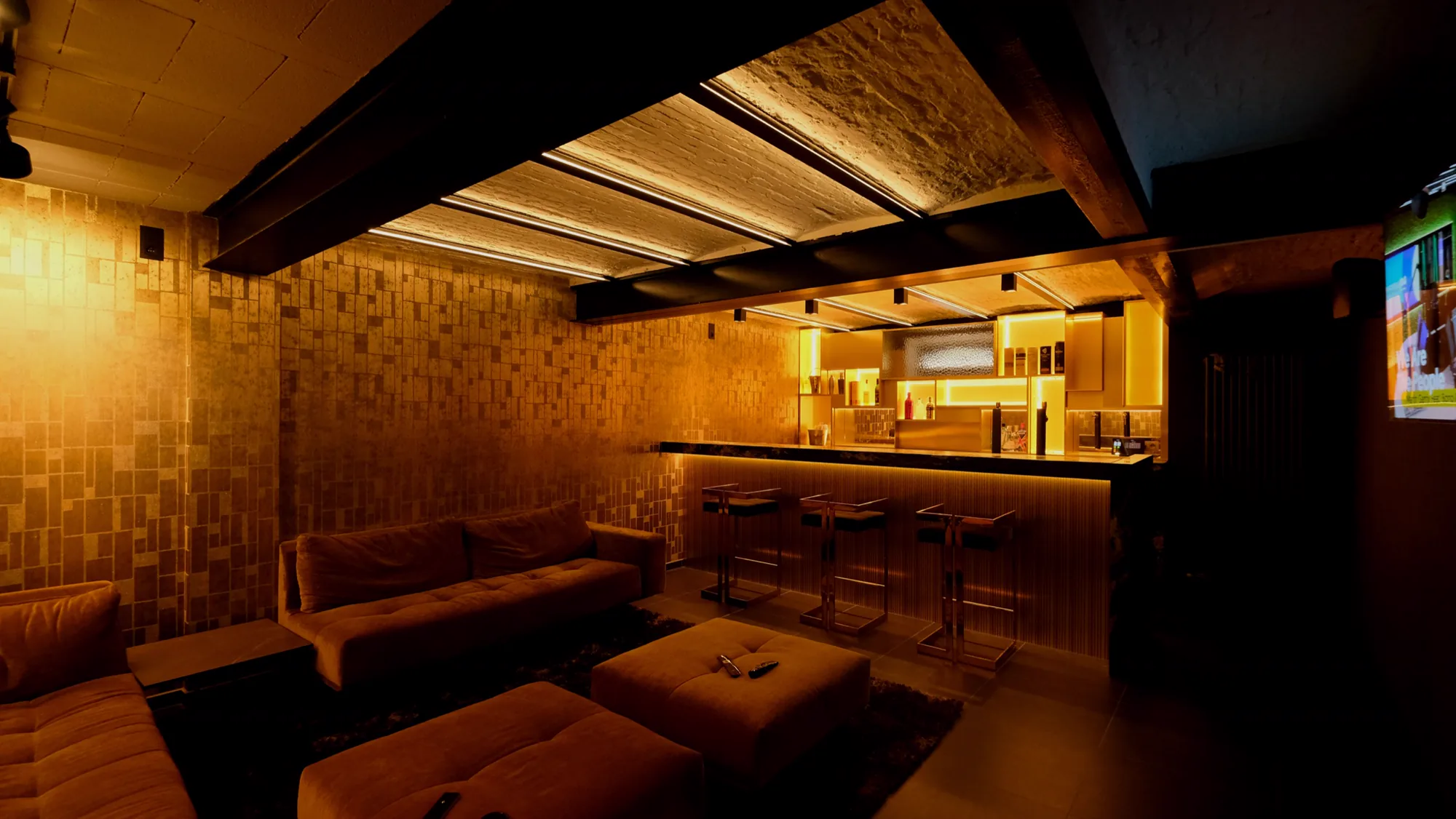 Basement of a Leuven home turned into a lounge with bar and warm light