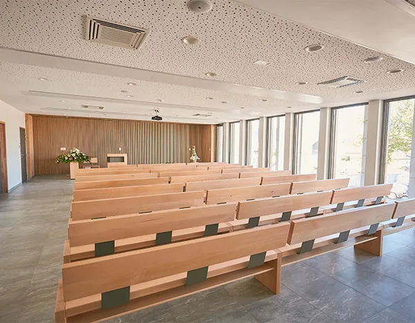 Bright ceremony room with wooden benches in a funeral home