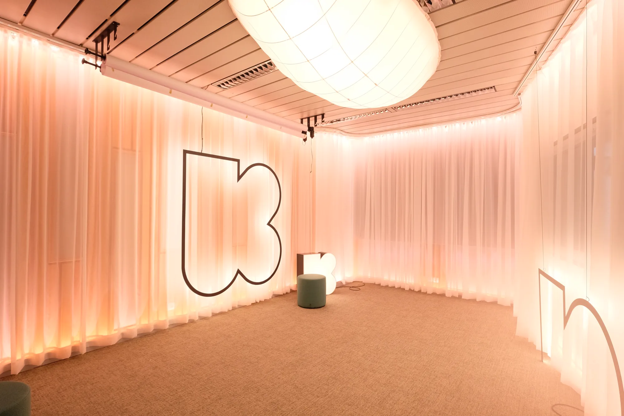 Klara media room with lit drapes, cloud lamp and steel Klara logo