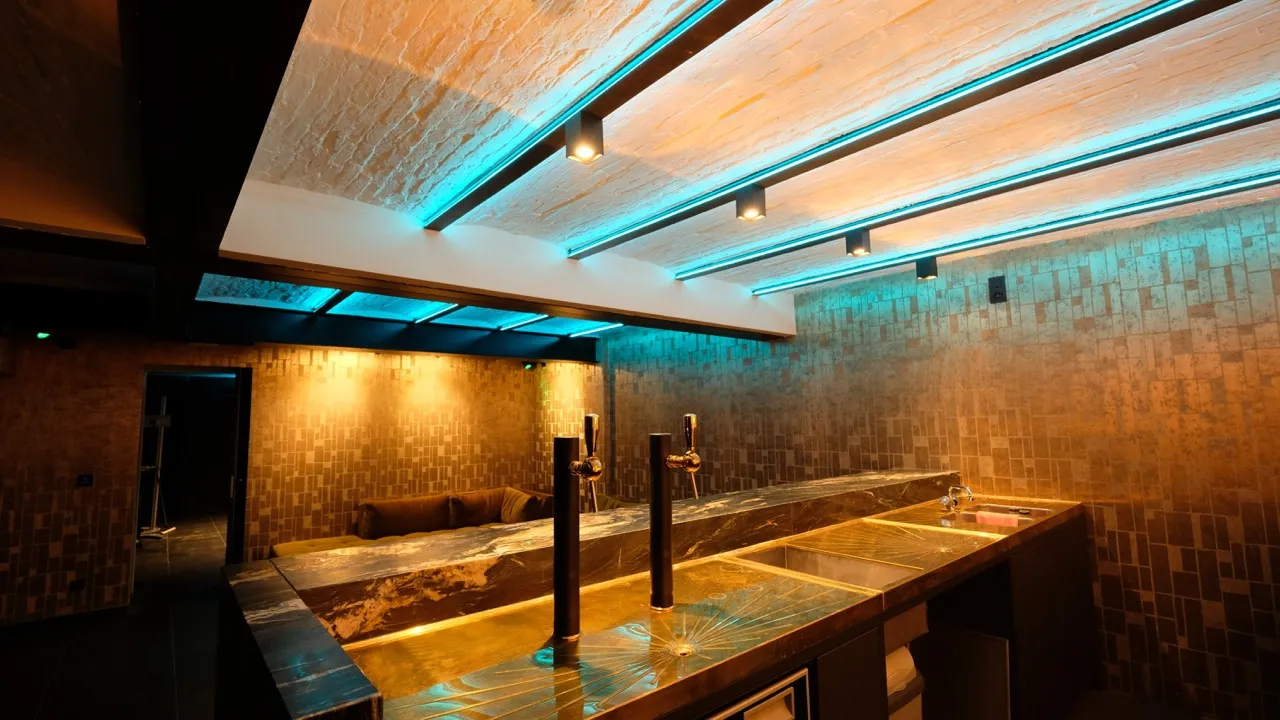 RGBW LED strips recessed into the ceiling above a wooden bar