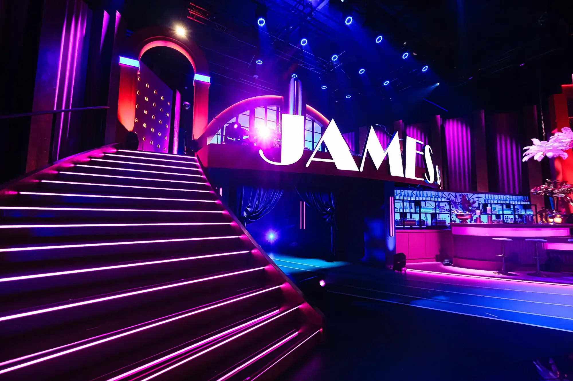 Staircase lined with pink LED strips beneath the James & Co studio letters