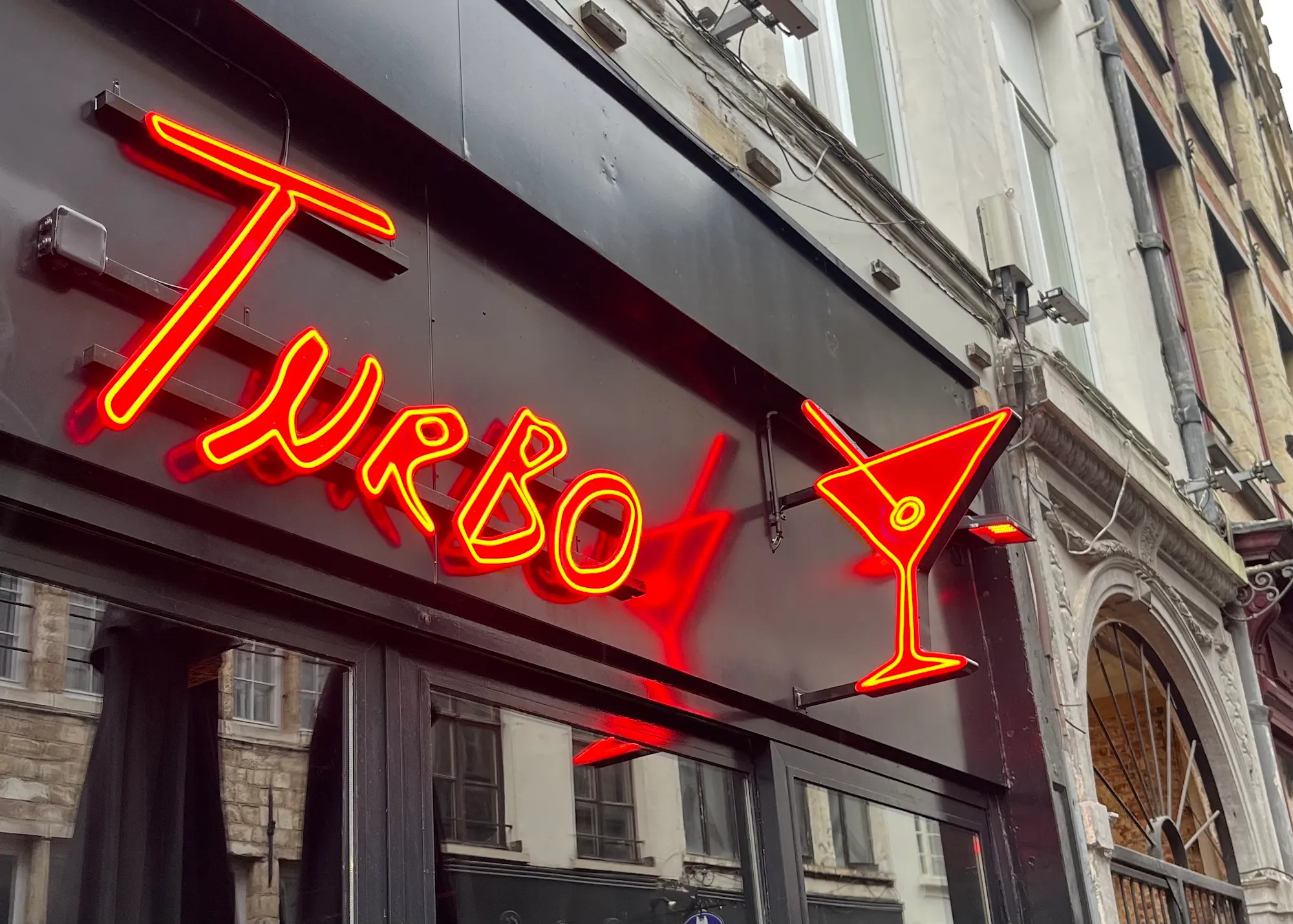 Red neon logo with cocktail glass on the Turbo facade in Antwerp