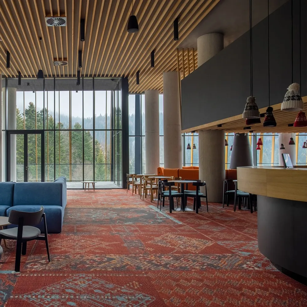 Spacious hotel lounge with a timber slatted ceiling and discreet background music