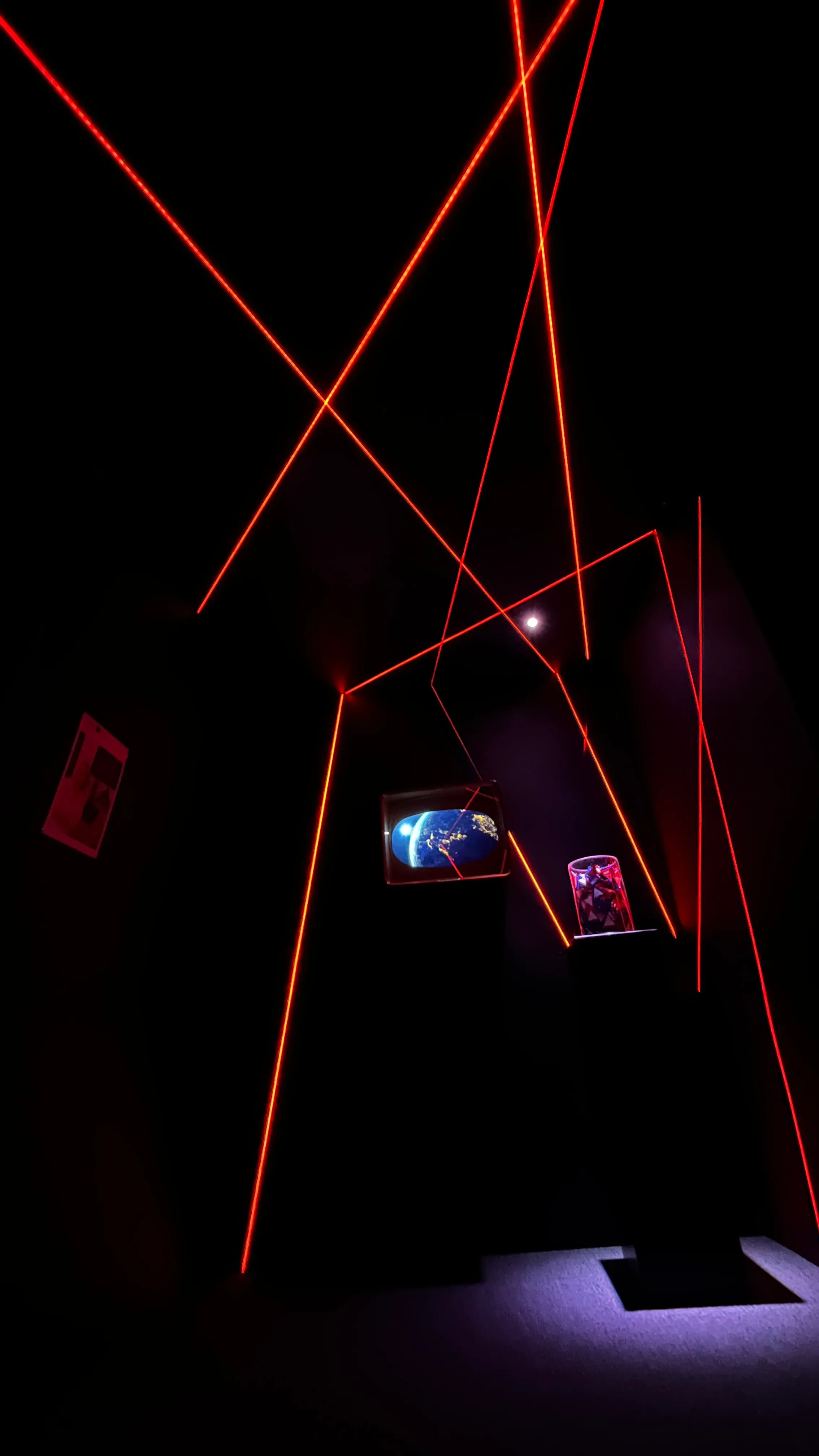Red LED lines criss-crossing a dark entrance hall