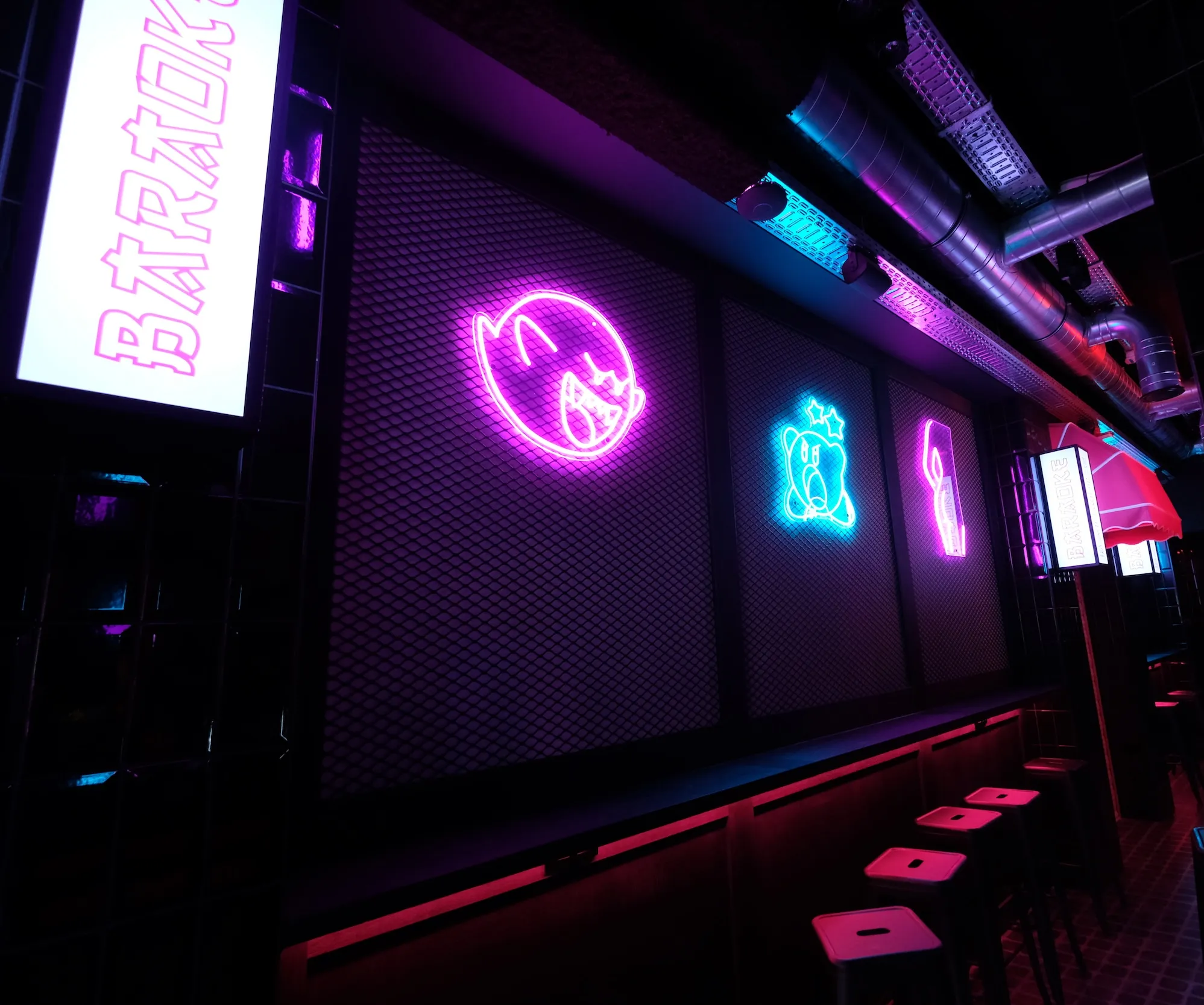 Pink and blue neon logos on the wall of Baraoke in Ghent